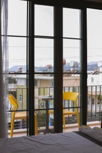 a bedroom with a bed and two yellow chairs at Limon Inn Hotel, Taşucu in Tasucu