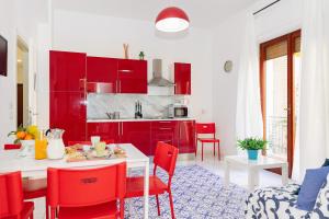 a kitchen with red cabinets and a table and chairs at Residence Sorrento 2 in Sorrento