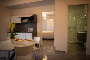 Zimmer mit einem Esstisch und einem Schlafzimmer in der Unterkunft LeTagghjate - Exclusive Rooms and Suites in San Giorgio Ionico