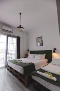 a bedroom with two beds and a large window at Limon Inn Hotel, Taşucu in Tasucu