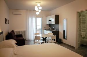 Zimmer mit einem Tisch und Stühlen sowie einer Küche in der Unterkunft LeTagghjate - Exclusive Rooms and Suites in San Giorgio Ionico