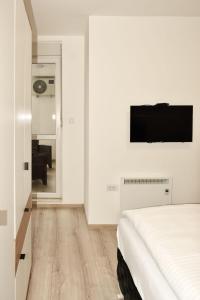 ein Schlafzimmer mit einem Bett und einem TV an der Wand in der Unterkunft Apartman Biser 4 in Ruma