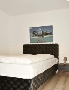 ein Bett mit einem schwarzen Kopfteil in einem Schlafzimmer in der Unterkunft Apartman Biser 4 in Ruma