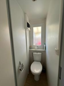 a small bathroom with a toilet and a window at Camping Sable du Midi MH 6-8 personnes in Valras-Plage