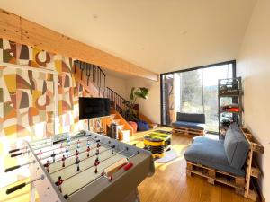 a living room with a pool table in the middle at Les GRANDS enfants - 1h15 de Paris - Piscine intérieure chauffée - Offres Pro in Subligny