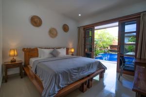 een slaapkamer met een bed en een groot raam bij Wiras Village in Canggu +24 foto's