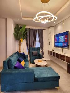 a living room with a blue couch and a tv at Ezra courts apartments in Lekki