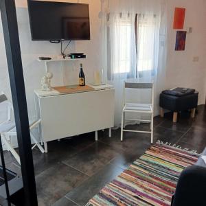 sala de estar con TV y escritorio blanco en La Casita, en Capileira