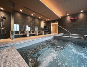 een badkamer met een groot zwembad met water bij Boutech JianTan Hotel in Taipei