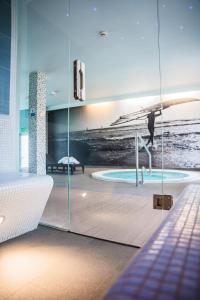 a room with a swimming pool and a bath tub at Hotel Meridian in Chałupy