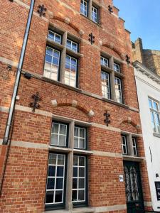 a brick building with windows on the side of it at Guesthouse Aubrey - Charming Cottage in the Heart of Bruges in Bruges