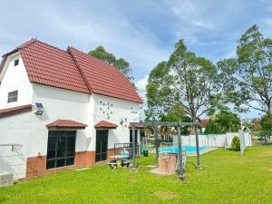 ein Haus mit einem Spielplatz im Hof in der Unterkunft A’famosa Moments villa 924 covered Bbq KTV pool in Kampong Alor Gajah