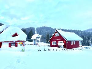 een rood huis in de sneeuw naast een gebouw bij Arctic House in Dolný Kubín +37 foto's