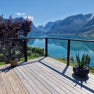 a deck with a view of a lake and mountains at Flo Bellevue in Stryn
