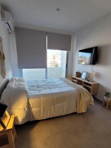 a bedroom with a bed and a flat screen tv at Excelente Apartamento Centro Opcional Cochera by Lofter in La Plata