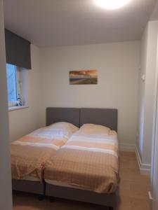 un letto in una camera da letto con un dipinto sul muro di Oostduinkerke Res Henri IV a Oostduinkerke