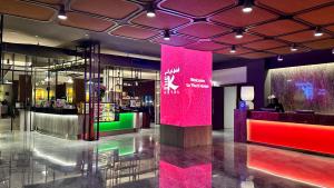 een lobby met een roze muur in een gebouw bij The K Hotel in Manamah