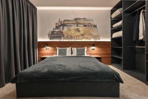 um quarto com uma cama e um quadro na parede em Tvrdjava Rooms em Novi Sad