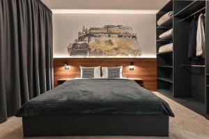 a bedroom with a bed and a painting on the wall at Tvrdjava Rooms in Novi Sad