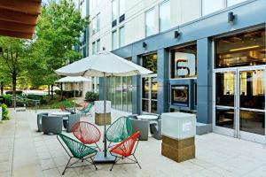 a group of chairs and an umbrella in front of a building at Aloft Nashville Franklin in Franklin