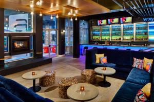 eine Bar mit Sofas, Tischen und TV in der Unterkunft Aloft Nashville Franklin in Franklin