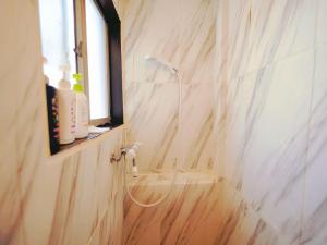 a bathroom with a shower with a sink and a window at Nippori Osaka Nishi-Tengachaya Guesthouse西天下茶屋アパートメント in Osaka