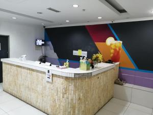 a bar in a room with a colorful wall at Hotel Rim Global Pj21 in Kampong Baharu Sungai Way
