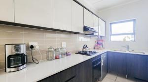 a kitchen with a microwave and a counter top at The Sandown Blouberg self catering unit in Parklands