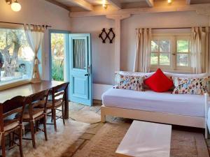 Schlafzimmer mit einem Bett und einem Esstisch in der Unterkunft Olive Grove Cottage - Excellent View in Lefkada Town