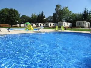 ein großer Pool mit Rutsche und Spielplatz in der Unterkunft Mobile Home Gorecki in Lidzbark Warmiński