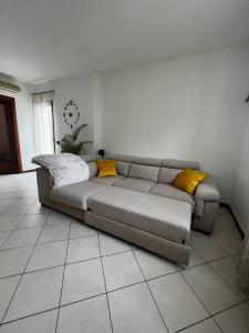 - un canapé dans le salon avec des oreillers jaunes dans l'établissement Quello Giusto a Fregona, à Fregona