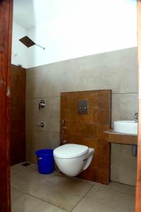 a bathroom with a toilet and a sink at Krishna Dhwani Apartments in Tellicherry