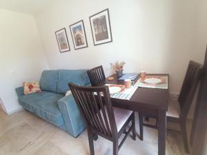 - un salon avec une table et un canapé bleu dans l'établissement Appartement Torremolinos Dona Carlota, à Torremolinos