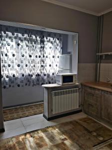 een keuken met een magnetron en een raam bij Алматы квартира. 31 in Alma-Ata
