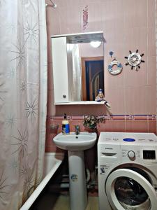 een badkamer met een wasmachine en een wastafel bij Алматы квартира. 31 in Alma-Ata