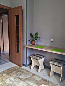 a room with a desk with two stools and a plant at Алматы квартира. 31 in Almaty