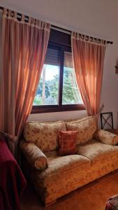 un sofá en una sala de estar con ventana en Casa Rural La Era 3 - Adults Only, en Aracena