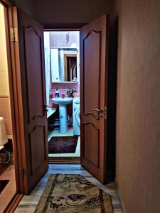 een open deur naar een badkamer met een wastafel bij Алматы квартира. 31 in Alma-Ata