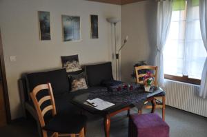 uma sala de estar com uma mesa e um sofá em Ferienwohnungen Alter Raaben em Rüti