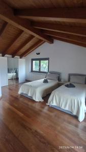 Habitación grande con 2 camas y suelo de madera. en Lake Como Sky Villa Retreat, en Como