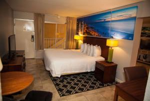 a hotel room with a bed and a table at Days Inn by Wyndham Cocoa Cruiseport West At I-95/524 in Cocoa