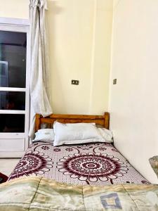 a bedroom with a bed with a brown and white bedspread at Calm 2BR Home with Garden in New Cairo in Cairo