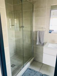 a shower with a glass door in a bathroom at Joy Apartment@The Blyde in Pretoria