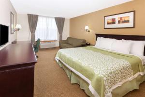a hotel room with a bed and a television at Days Inn & Suites by Wyndham Tucker/Northlake in Tucker
