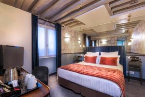 パリにあるドフィネ サン ジェルマンのベッドとデスクが備わるホテルルームです。