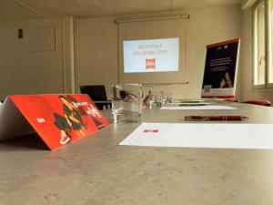 une table avec des papiers et des stylos et un livre sur celle-ci dans l'établissement Ibis Brive Centre, à Brive-la-Gaillarde