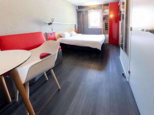 a room with two beds and a table at ibis Vesoul in Vesoul