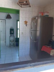 eine Küche mit einem Kühlschrank aus Edelstahl in einem Zimmer in der Unterkunft Chalé Pé na Areia, Cond. Beira Mar, Maragogí/AL in Maragogi