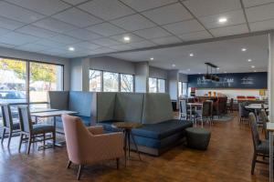 a restaurant with a couch and tables and chairs at Hampton Inn Athens in Athens