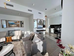 a living room with a couch and a kitchen at 1BR Americana Apartment: Stars and Stripes Haven in Abu Dhabi